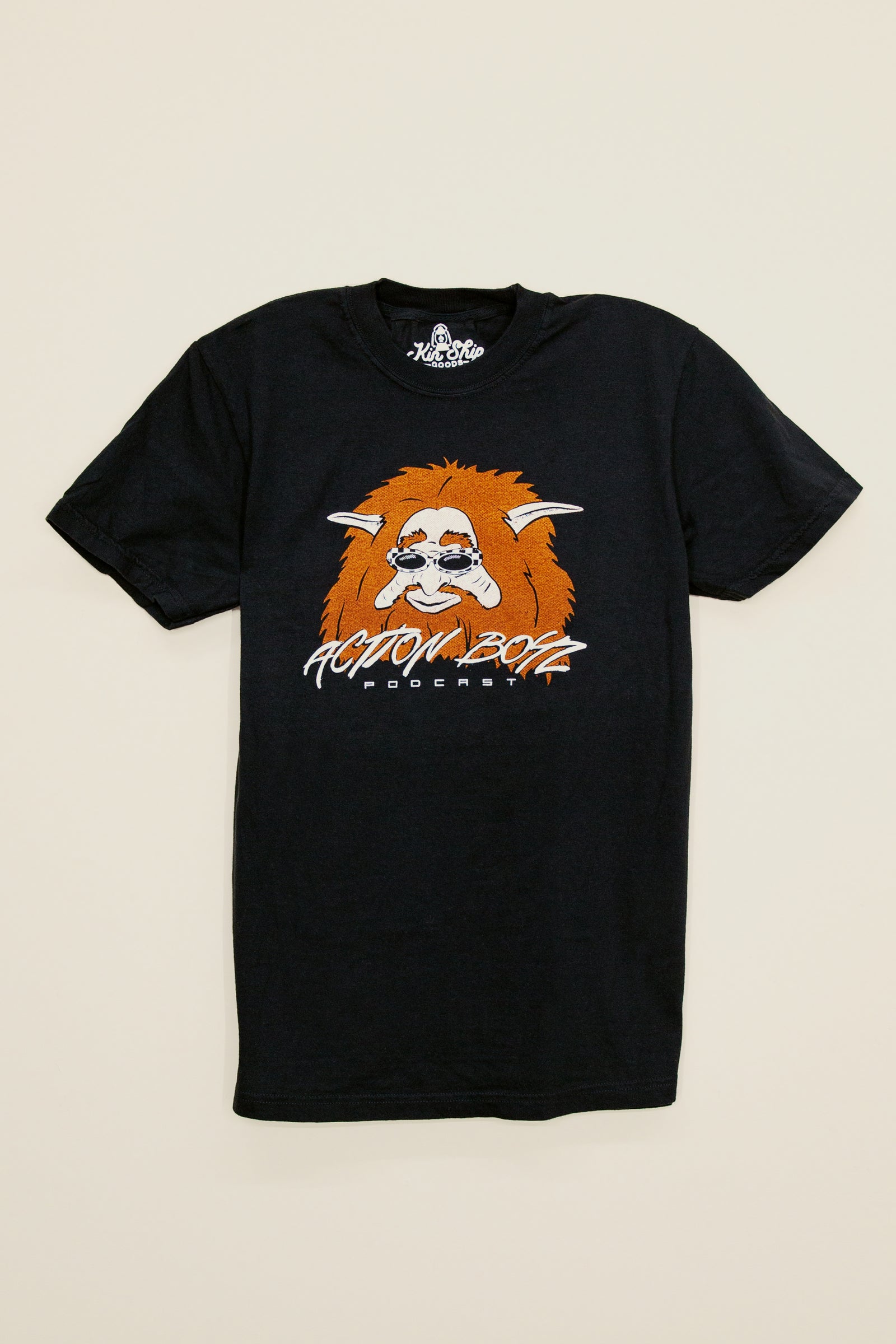 Kin Ship Goods black t-shirt with fuzzy creature face and Action Boyz Podcast logo—official podcast merchandise.