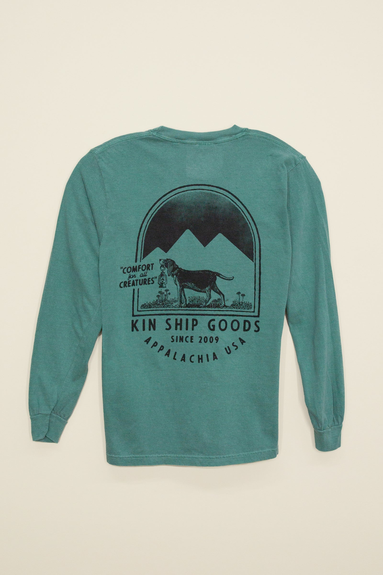 Kin Ship Goods teal long sleeve with ‘Comfort for all Creatures’ mountain dog graphic on back, screen printed in black ink.