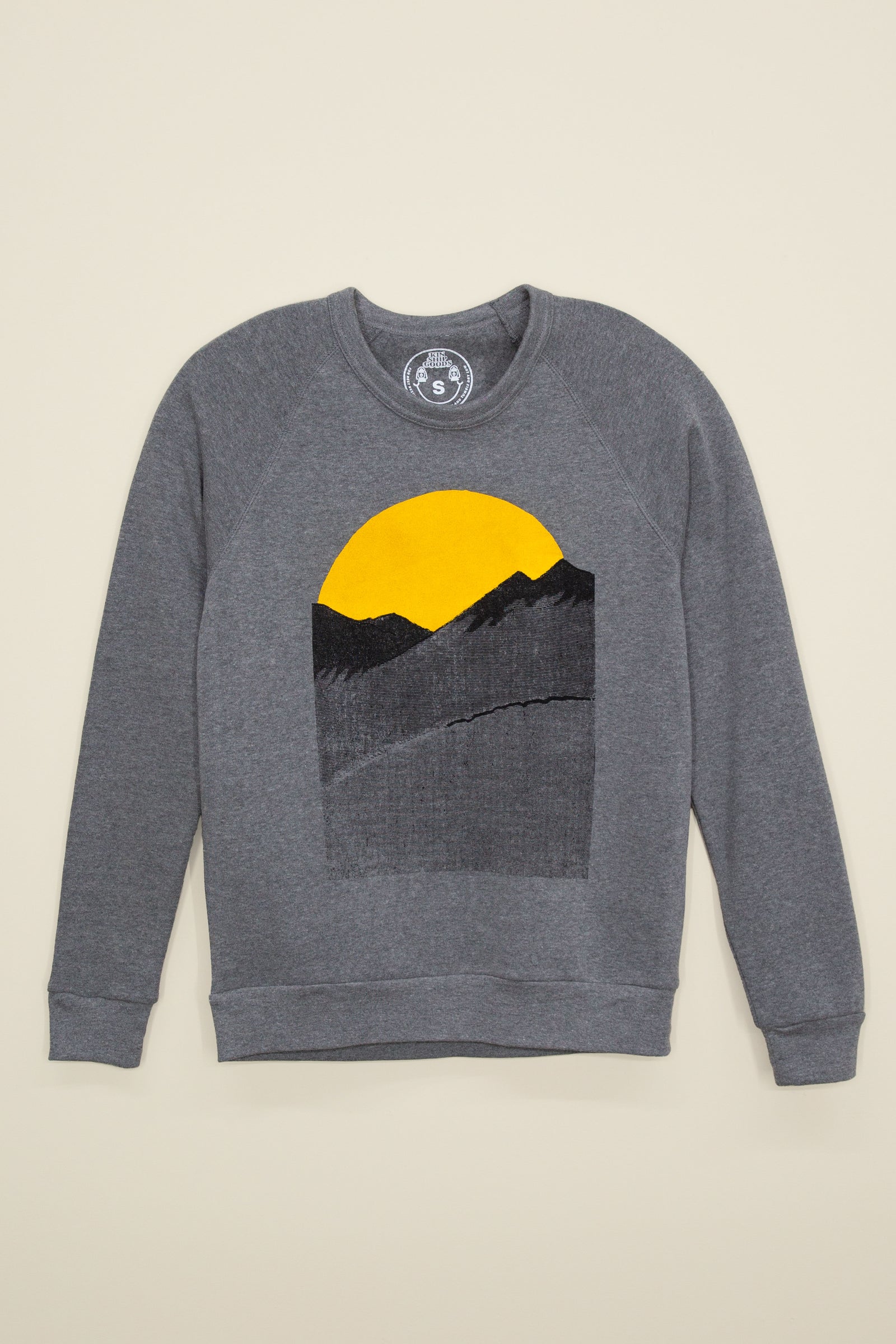 Kin Ship Goods gray sweatshirt with yellow sun and black mountain print, as seen on Mindy Kaling and Reggie Watts.