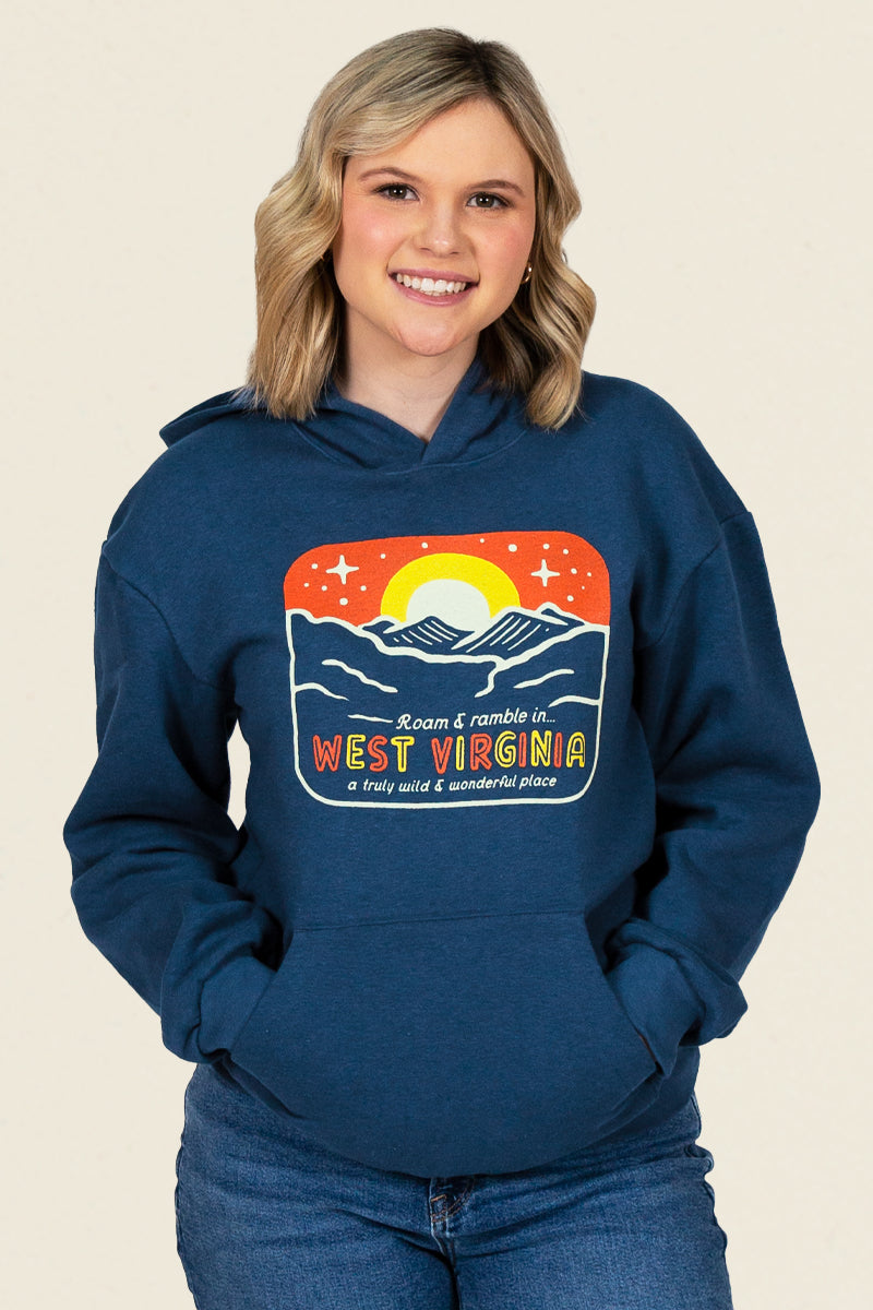 Kin Ship Goods retro West Virginia hoodie with mountain sunrise graphic and 'Roam & Ramble' text on navy blue fabric.