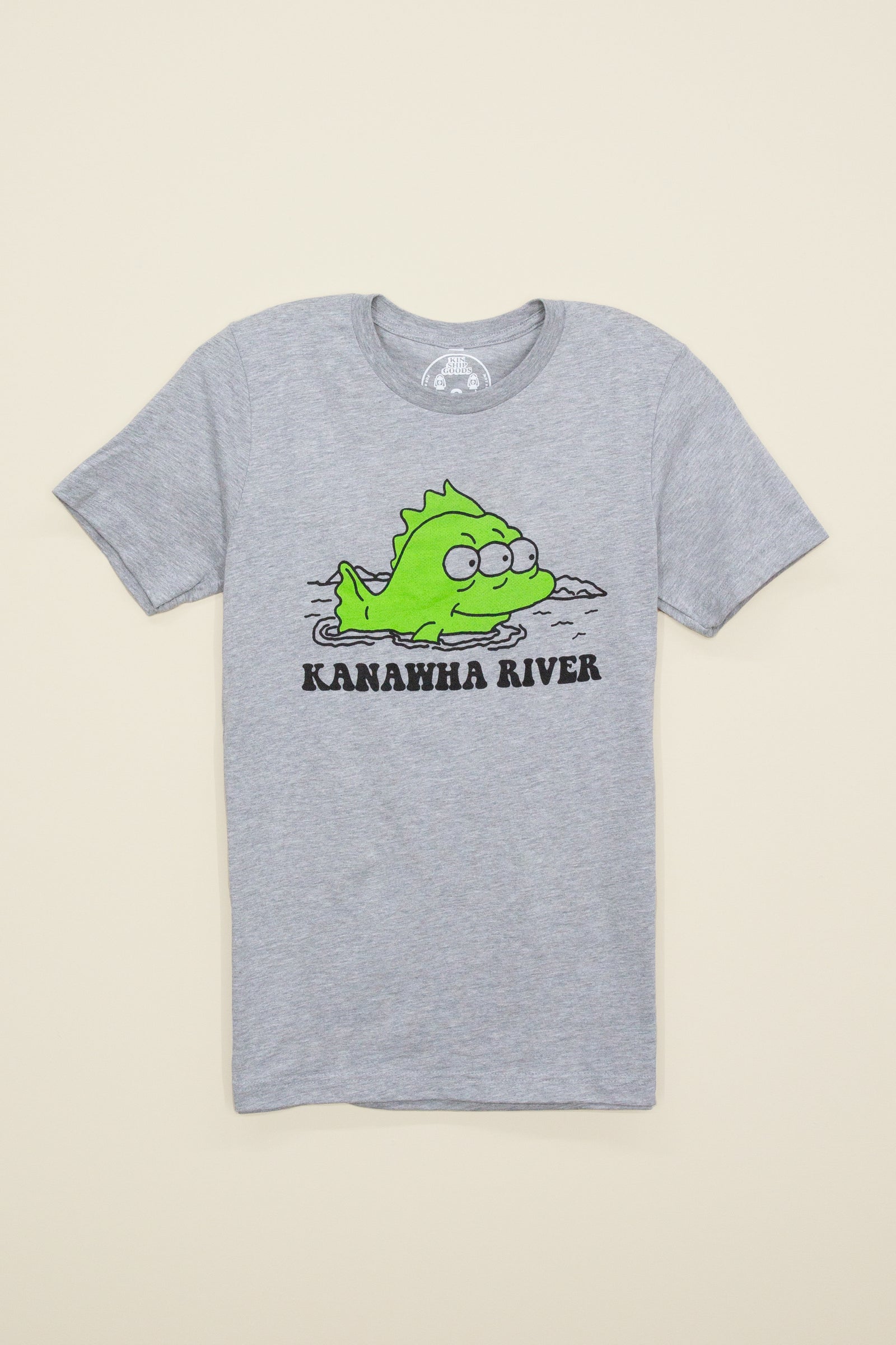 Kin Ship Goods gray tee with cartoon green fish and text reading 'Kanawha River,' inspired by local Charleston river lore.