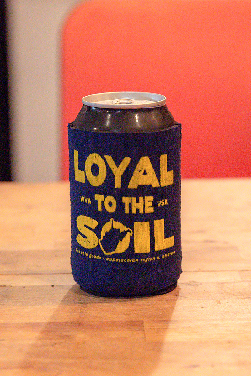 Kin Ship Goods “Loyal to the Soil” koozie with yellow West Virginia graphic on navy background—Appalachian pride drink holder.

