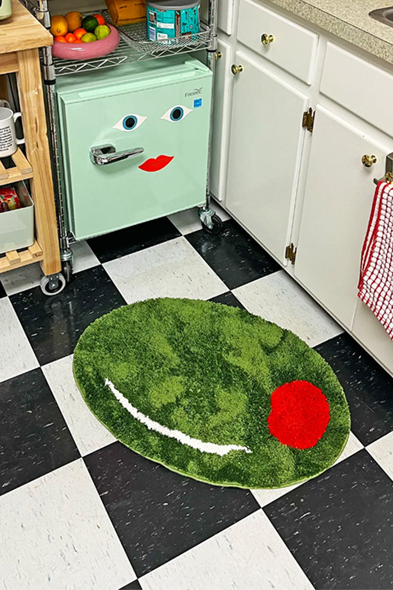 Kin Ship Goods olive-shaped rug with green tufting and red pimento detail

