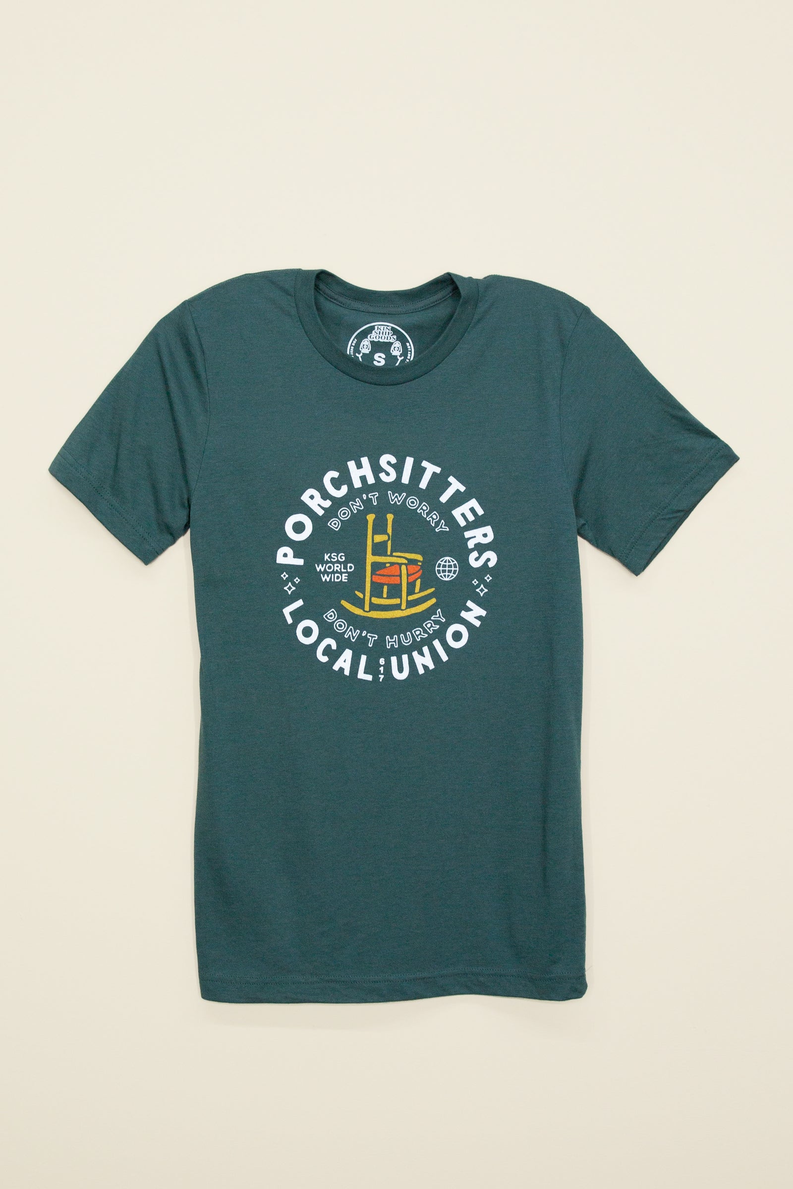 Kin Ship Goods forest green tee with ‘Porchsitters Local Union’ graphic, featuring a yellow rocking chair and retro union-style seal.